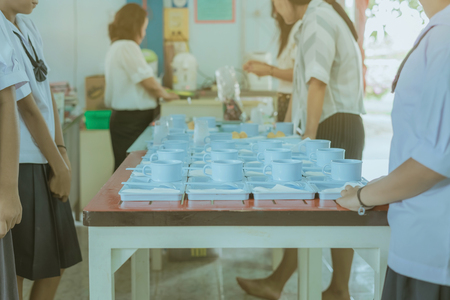 Students prepare snack and beverage for conference lunch breakの写真素材