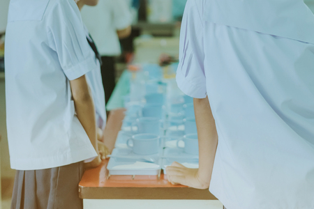 Students prepare snack and beverage for conference lunch breakの写真素材