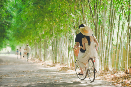 Happiness couple ride a bicycle in the bamboo parkの写真素材