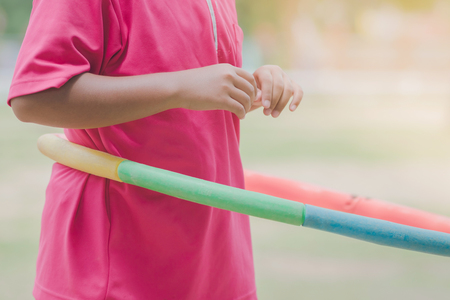 Female students doing exercise with a hula-hoop for a good healthy at school.の写真素材
