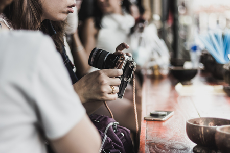 Young woman prepares a camera ready to take a photo at riverside of Amphawa, Thailandの写真素材