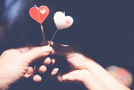 Romantic couple on valentines day. Happy joyful couple give heart candle to each other in the afternoon, Love concept.の写真素材