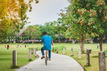 People exercising by cycling in the evening at the public park.の写真素材