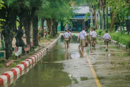 KANCHANABURI THAILAND - MARCH 9 :   Unidentified Students walk to the flood after rain to change class on March 9,2018 at Watkrangthongratburana school in Kanchanaburi, Thailandのeditorial素材