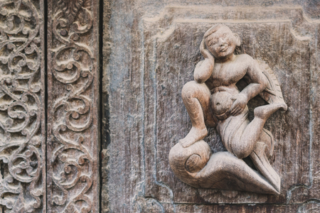 Archaeological, Close Up of carved art figures on old wood carvings on the wall temple at Shwe Nan Daw Kyaung (Golden Palace Monastery) in Mandalay, Myanmarの写真素材