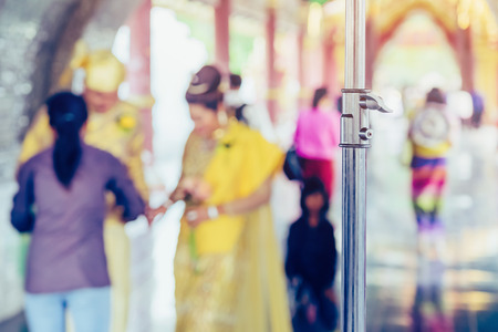 Myanmar wedding photography. A Burmese couple in a tradition dress that was photographed by a wedding photographer and his assistant in a famous temple. Villagers believe this brings good luck to young couples. Selective focus on Flash light standの写真素材