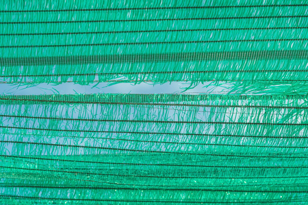 The Old green sun protection mesh and lack. Can not prevent sunlight.の写真素材