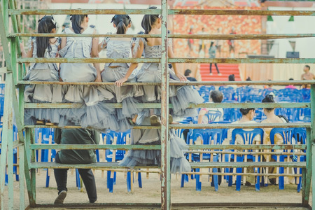 Young girls sit on the grandstand to wait for the stage performance.