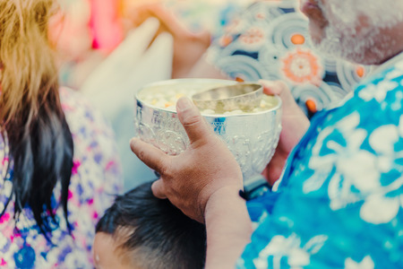 People are holding a bowl of water perfume with flower preparing to shower for the monks on Songkran day.(Thailand New Year)の写真素材