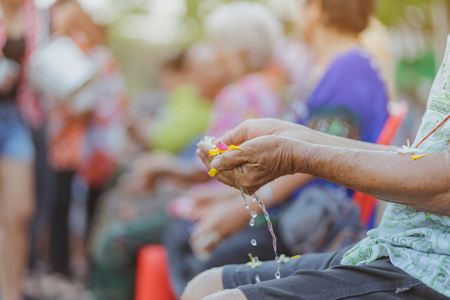 Thai people celebrate Songkran by pouring water and giving garlands to elder senior or respected grandparents and elder and asked for blessings for celebrate Songkran in new year water festivalの写真素材