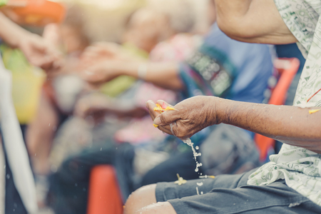 Thai people celebrate Songkran by pouring water and giving garlands to elder senior or respected grandparents and elder and asked for blessings for celebrate Songkran in new year water festivalの写真素材