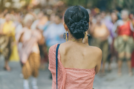 Back view of female in Thai dress  take a photo of a Thai dance parade in Songkran festival in Kanchanaburi Thailand.の写真素材