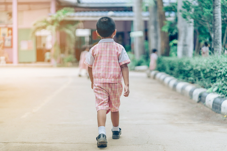 Back view of Boy followed girl friends on street to go to the classroom in school.の写真素材