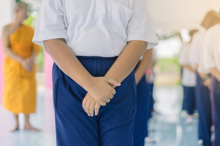 Group of students try to meditate for the peace of mind by walk with Buddhist monk in school.