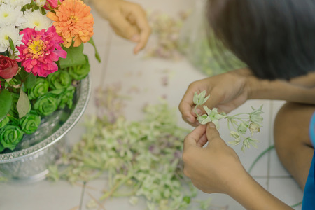 Students help each other to create a flowers tray with pedestal  for The Teachersâ Dayの写真素材