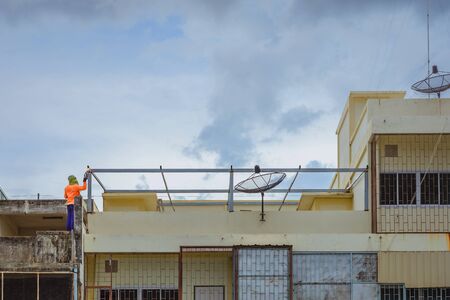 Worker welding the steel part for roof  before it is going to rain.