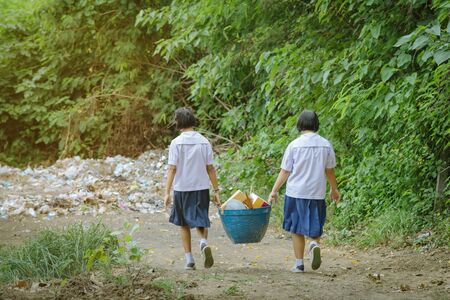 Female Students help to remove rubbish from the classroom to pile wasteの写真素材