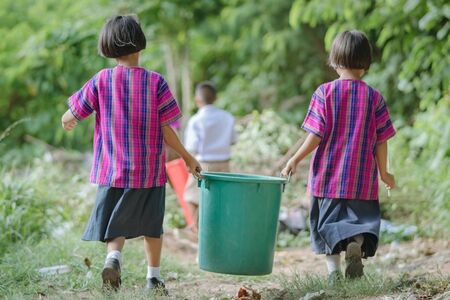 Female Students help to remove rubbish from the classroom to pile wasteの写真素材