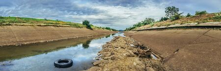 Irrigation canal in concrete wall Send water from the reservoir to the agricultural area of ââthe farmer that is dry in the rainy season of Thailand. Environmental disaster in agricultureの写真素材