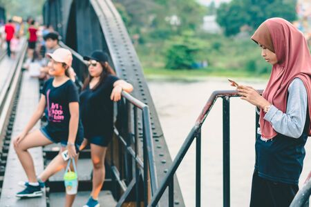 KANCHANABURI THAILAND - FEBRUARY 9 : Unidentified Muslim woman relax and admire the beautiful scenery in the evening at The Bridge of the River Kwai on February 9,2019  in Kanchanaburi, Thailandのeditorial素材
