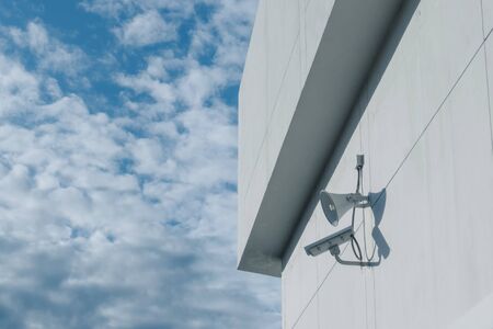 Loudspeakers and CCTV security cameras observation on a wall of a building