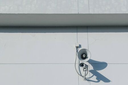 Loudspeakers and CCTV security cameras observation on a wall of a buildingの写真素材