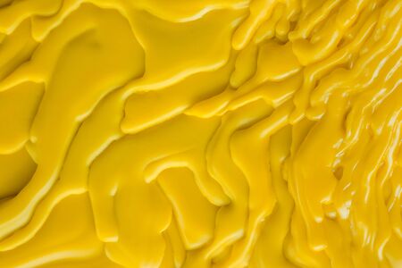 Top view of the candle melts droplets dissolve in yellow from lighted candlestick on the floor