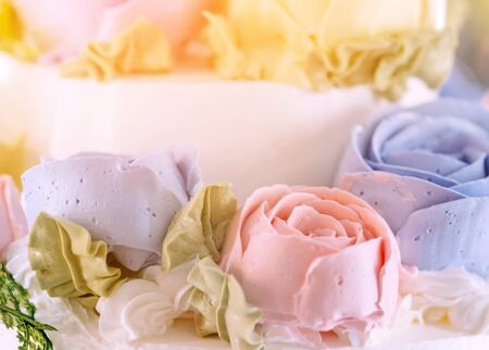 Close up to wedding cake decorated with roses and flowers for the groom and the bride in the wedding...