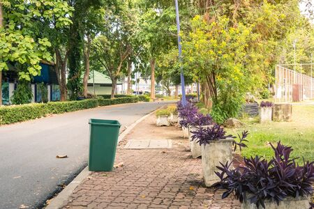 An old green dustbin in the public park beside the walk way for protect environment.の写真素材