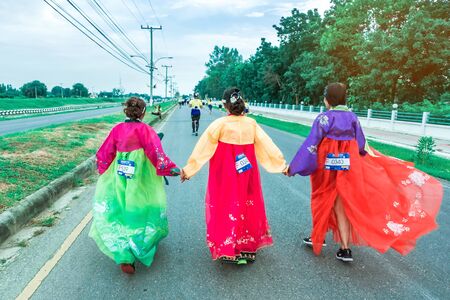 KANCHANABURI THAILAND - October 6 : Unidentified Thai women in traditional Korean national costumes run and take photography on the city road on October 6,2019 in Kanchanaburi, Thailandのeditorial素材