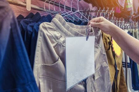 People check and choose pants to buy on hangers in a clothing store.の写真素材