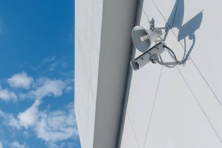 Loudspeakers and CCTV security cameras observation on a wall of a building