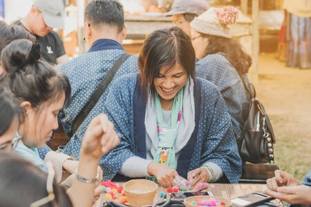 LAMPHUN THAILAND - DECEMBER 12 :  Unidentified Thai female tourists learn to make a necklace from a yarn ball on December12,2019 at Karen village in Lamphun, Thailandのeditorial素材