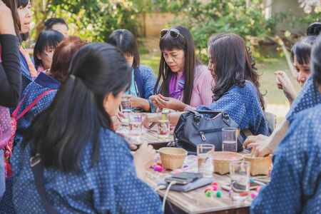 LAMPHUN THAILAND - DECEMBER 12 :  Unidentified Thai female tourists learn to make a necklace from a yarn ball on December12,2019 at Karen village in Lamphun, Thailandのeditorial素材