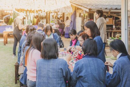 LAMPHUN THAILAND - DECEMBER 12 :  Unidentified Thai female tourists learn to make a necklace from a yarn ball on December12,2019 at Karen village in Lamphun, Thailandのeditorial素材