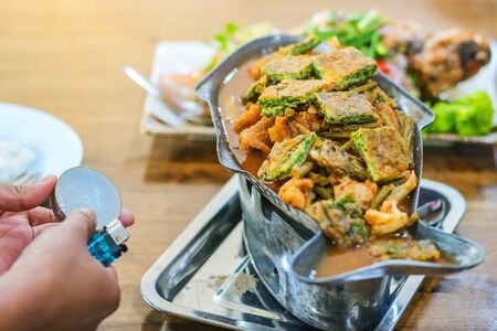 Group of female friends enjoy eating with acacia pennata omelette sour soup in fish shape hot pot in...