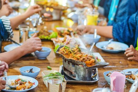 Group of female friends enjoy eating with acacia pennata omelette sour soup in fish shape hot pot in the restaurant. Selective focus.の写真素材