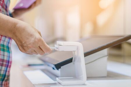 Close up to woman use the identification card inserted into the identity verification machine to...