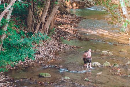 A group of children are walking to explore the nature of the stream at Hin Dad hot spring in Kanchanaburi, Thailand.の写真素材