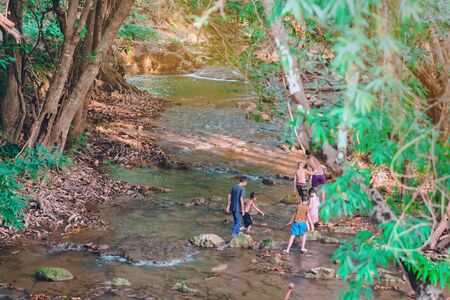 A group of children are walking to explore the nature of the stream at Hin Dad hot spring in Kanchanaburi, Thailand.の写真素材