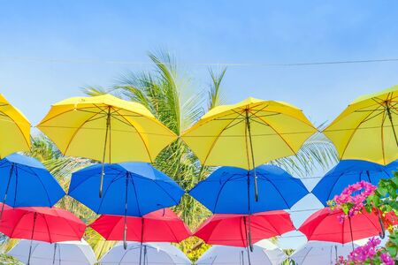 Street decorated with colorful umbrellas hanging on top side in the sky. Colorful umbrellas background.の写真素材
