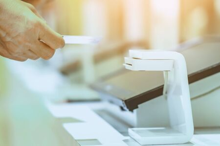 Close up to woman use the identification card inserted into the identity verification machine to...