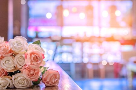 Beautyful bouquet of pink artificial roses placed on the table to decorate the coffee shop.の写真素材