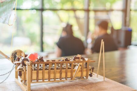 Red heart shaped candle on a turbine baler model made of wooden on table with blur couple in...