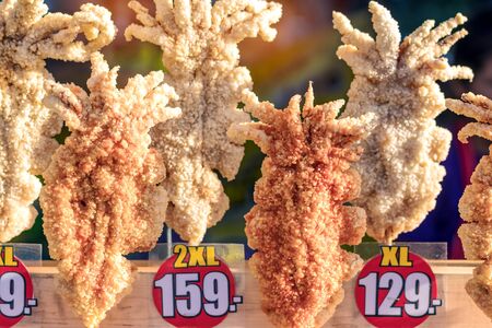 Large fried Japanese squid fried on skewers for sale in street food in Thailand.