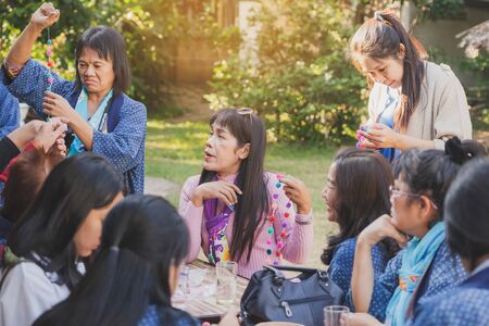 LAMPHUN THAILAND - DECEMBER 12 :  Unidentified Thai female tourists learn to make a necklace from a yarn ball on December 12, 2019 at Karen village in Lamphun, Thailandのeditorial素材