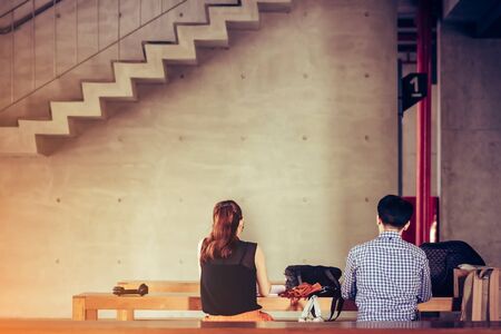Back view of Asian master degree students work and consult while staying on the first floor below the school building in the afternoon.の写真素材