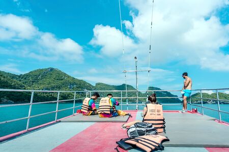 SAMUI ISLAND, THAILAND - OCTOBER 13, 2019 : Tourists relaxing on boat deck and looking to the...