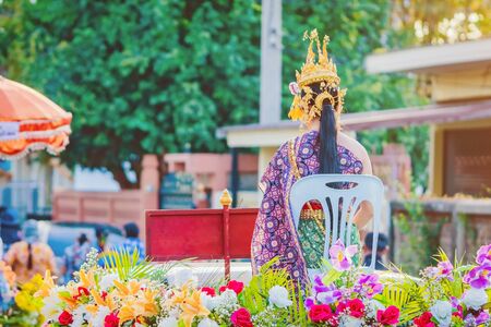 Beautiful with traditionally dressed woman is crowned to be "Miss Songkran" sit on pickup truck in parade on Songkran Festival in Thailand.の写真素材