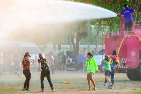 KANCHANABURI, THAILAND - APRIL 17, 2019: Unidentified Thai people in wet clothes fun with fire truck pours water on people from a hose water during Songkran festival at temple on april 17,2019 in Kanchanaburi, Thailand.のeditorial素材